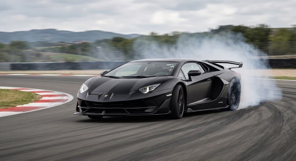 Black Lamborghini Aventador SVJ on a race track